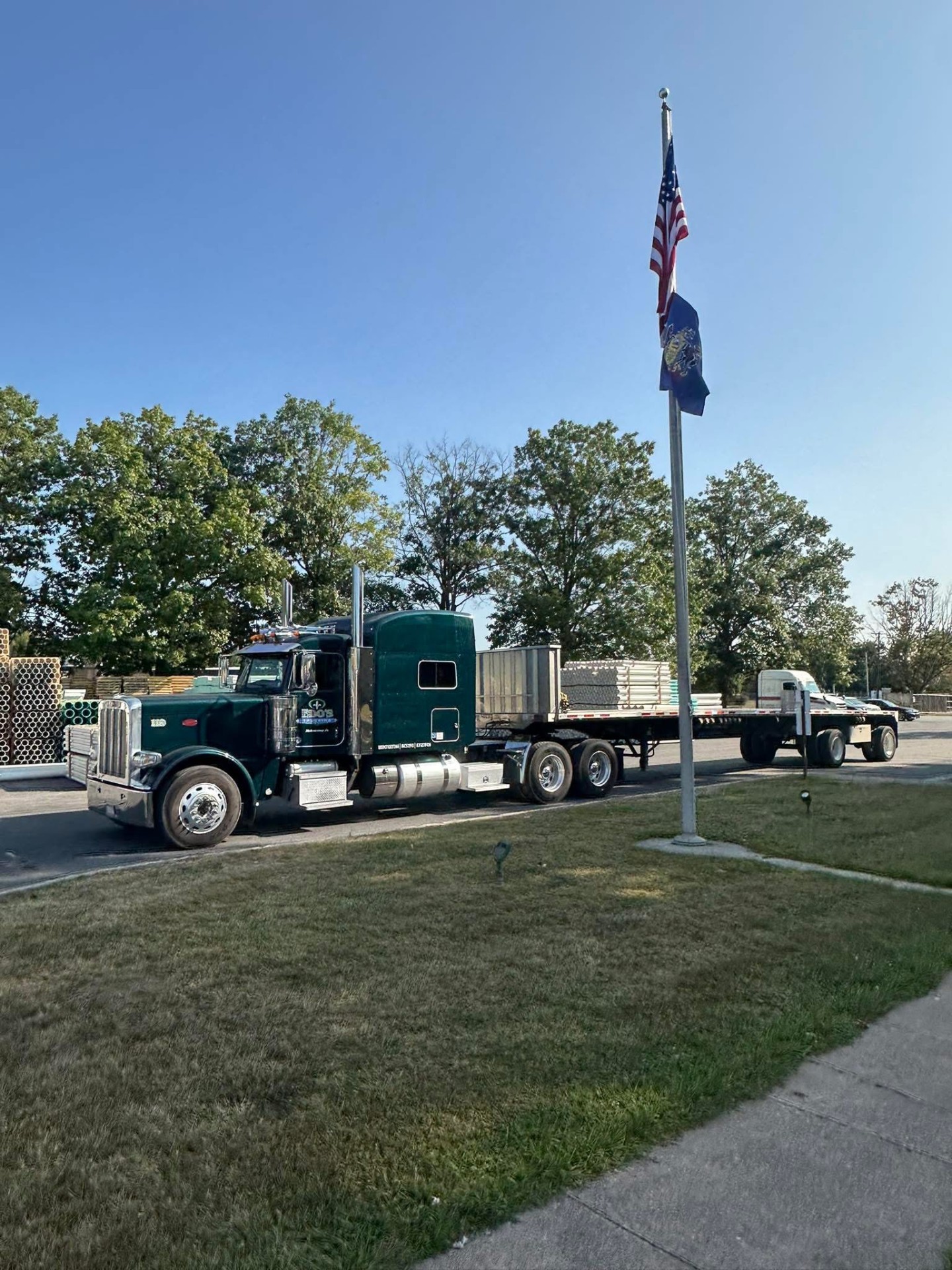 Green Peterbilt with flatbed and US flag